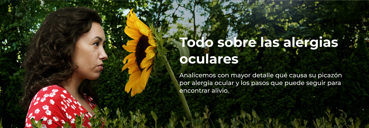 Una mujer con un vestido rojo de estampado floral de pie, mirando fijamente hacia un gran girasol amarillo.